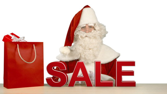 Santa Claus is Sitting Behind the Letters Which Form the Word SALE 