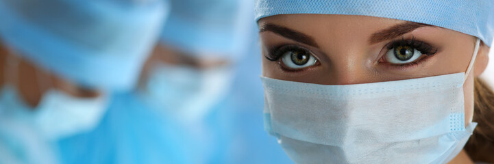 Three surgeons at work operating in surgical theatre