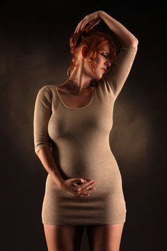 Eine schwangere Frau steht Model für Schwangerschaft und Mode