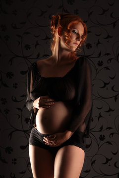Eine schwangere Frau mit Babybauch schön und erotisch fotografiert