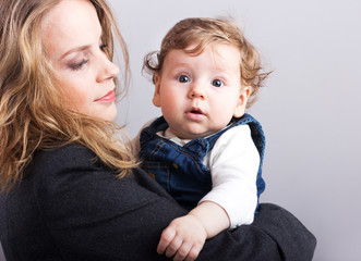young mother with a little boy in her arms. Portrait of mother and son. Beautiful blonde. pectoral baby. happy family
