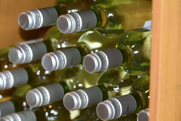 White wine bottles stacked high in wine shop