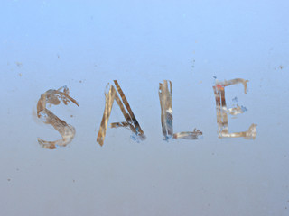 "sale" written on frosty winter window background.