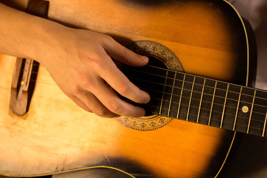 Young guy playing on guitar. Hand and guitar close-up.Soft and blur conception