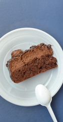 Piece of a chocolate cake in a disposable plate