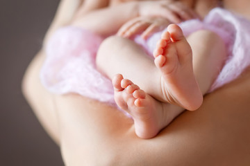 Close up picture of new born baby feet on a white and pink plaid