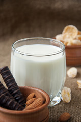 A glass of milk with almond nuts, corn flakes, chocolates,  on s