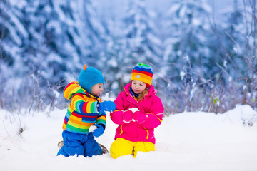 Fototapeta na wymiar Children playing in snowy winter park