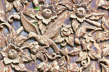 Carved bird and flowers on the wood background