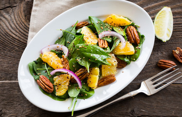 Salad with fresh spinach, oranges and pecan