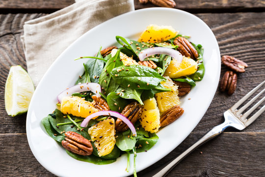 Salad with fresh spinach, oranges and pecan