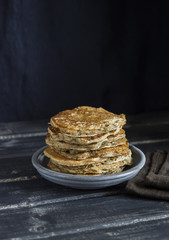 Healthy breakfast or snack - whole grain pancake, on a dark wooden table