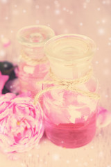Obraz na płótnie Canvas Rose oil in bottles on light background