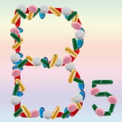 B 5 made of different pills on colour background