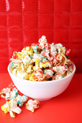 Sweet colourful popcorn on red background