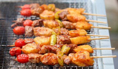 Meat and vegetable skewer on barbecue grill with fire