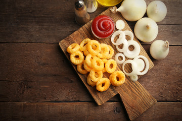 Chips rings with sauce and onion on cutting board