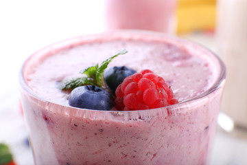 Milkshake with berries on light background, close-up