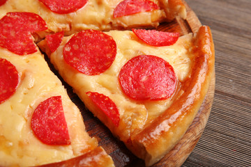 Hot tasty pizza with salami on wooden background