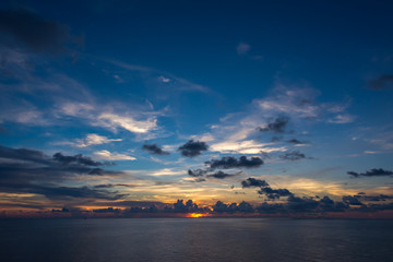 Naklejka na ściany i meble view of sunset into the ocean with twilight sky