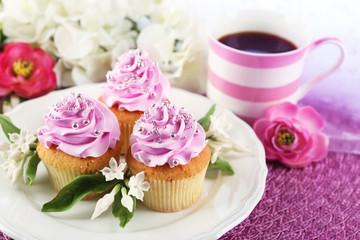 Tasty cupcakes on plate, on light background