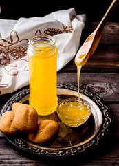 Flowing honey and cookies  on old metal tray.