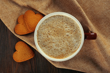 Cup of hot cacao with heart shaped cookies on cotton serviette, close up