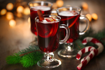 Mulled wine with spices and Christmas tree on wooden background