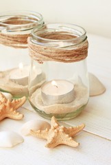 Beachy handcrafted candle lantern with sea sand for beach lovers. Jar with sand, seashells, tealight. Beige light soft tones.