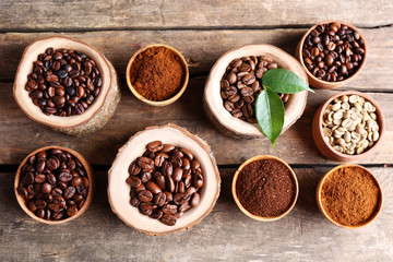 Different coffee beans on wooden table, close up