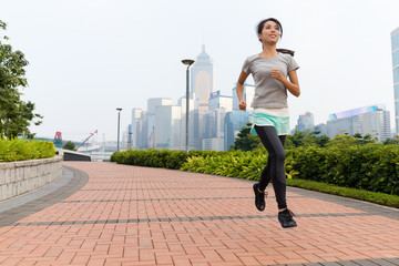 Fototapeta na wymiar Young Woman running in a city