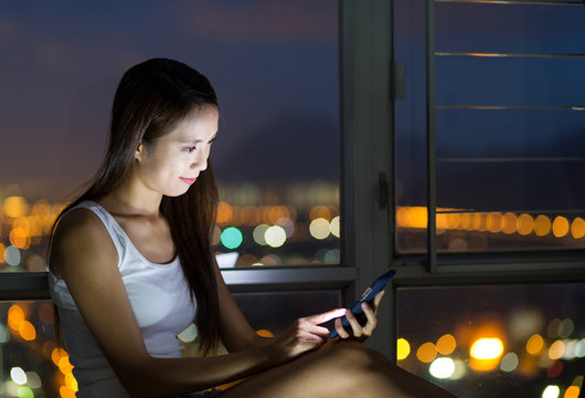 Woman use of the cellphone at night