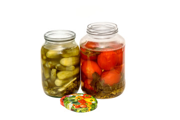 Fototapeta na wymiar canned cucumbers and tomatoes in glass jars on white