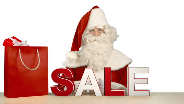 Santa Claus is Sitting Behind the Letters Which Form the Word SALE 