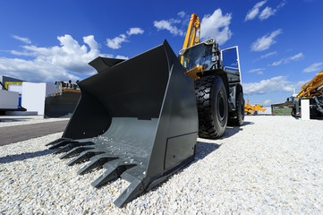 Loader, wheel bulldozer with big grey bucket, construction industry, heavy yellow excavator on...