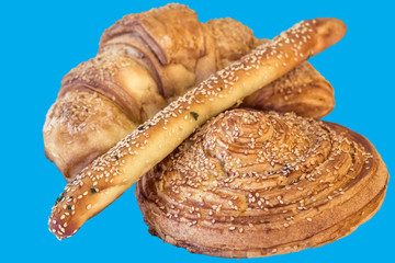 Croissant Puff Pastry Sprinkled with Sesame Seeds, Isolated on Blue Background.