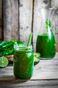 Green smoothie on rustic wooden background