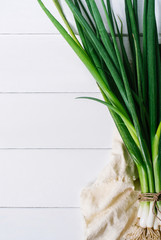 Onions on textiles on a light wooden background vertical top view
