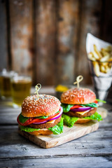 Homemade burgers on rustic wooden background
