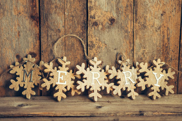 Wooden merry garland on rustic background