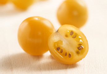 Whole and halved yellow cherry tomato