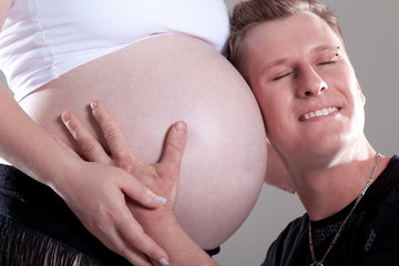 Papa Gesicht hört am Baybauch Nahaufnahme