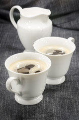Fototapeta na wymiar two cups of coffee on denim background