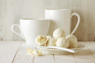Coconut candies pile in white plate and cups