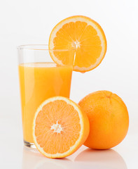 glass of orange juice and orange pieces