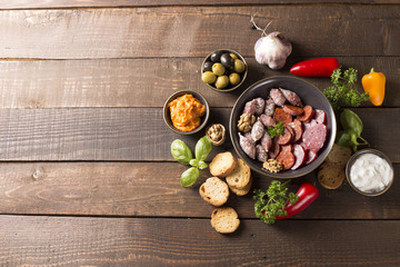 Obraz na płótnie Canvas appetizer with sausages,pesto,olive and nuts