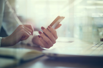 Modern workplace woman using mobile phone in office.