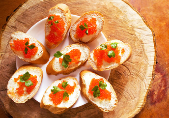 Sandwiches with salmon red caviar on wooden background