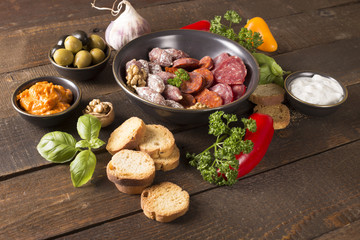 appetizer with sausages,pesto,olive and nuts