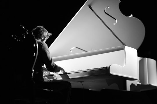 Young musician playing the grand piano